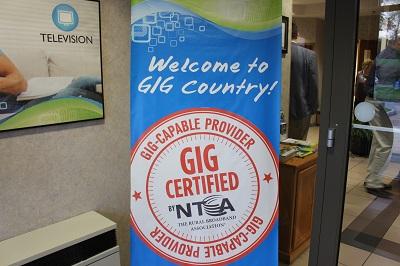A sign featuring a round, orange logo that reads, "Gig Certified by NTCA."